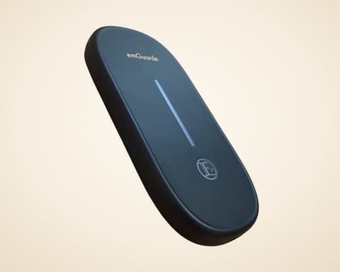 emGuarde från Enagic, en platt, oval enhet i matt svart med en ljuslist och Enagics logotyp